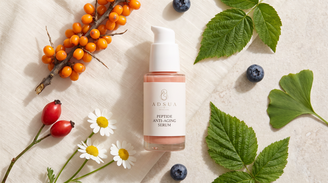 Adsua Peptide Anti-Aging Serum op linnen, omringd door duindoornbessen, rozenbottels, kamille, bosbessen en frambozenblad