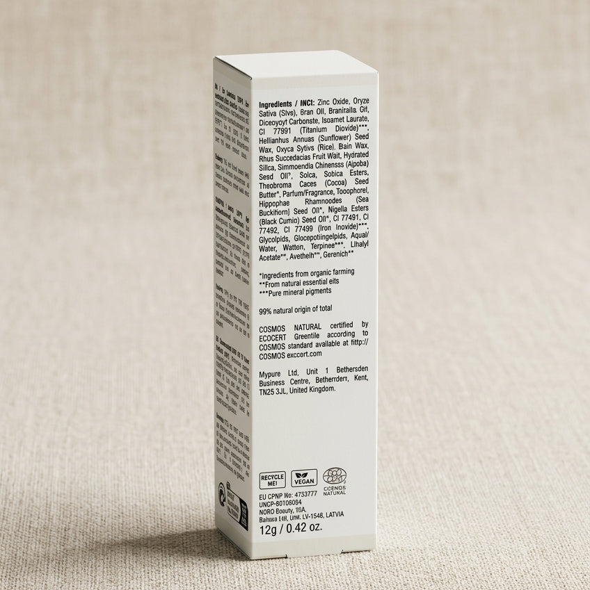 Achterkant van de Adsua Sun Protection SPF50 Stick with tint met de ingrediëntenlijst en het Ecocert COSMOS Natural-keurmerk