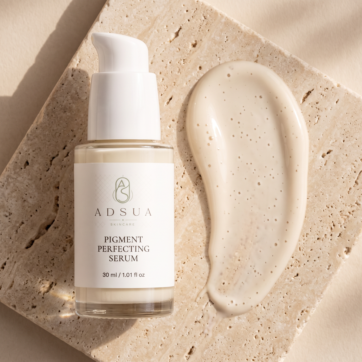 Adsua Pigment Perfecting Serum op travertijn met een veeg serum met luchtbelletjes
