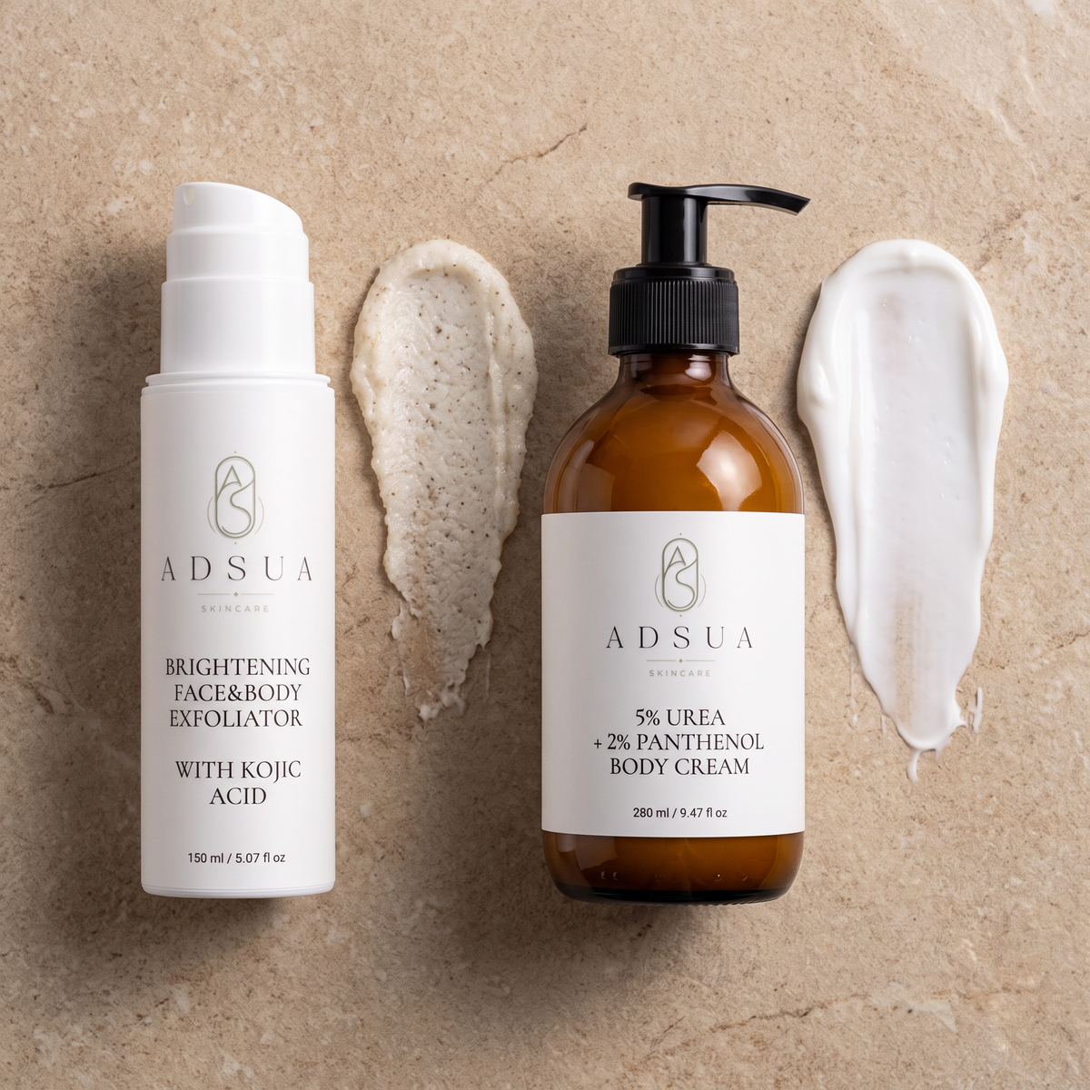 Adsua Derma Renewal Duo: de scrub met kojiczuur en de bodycreme met ureum, met een veeg scrub en creme ernaast